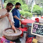 Vendor preparing traditional summer drink Sardai for customers at his roadside setup