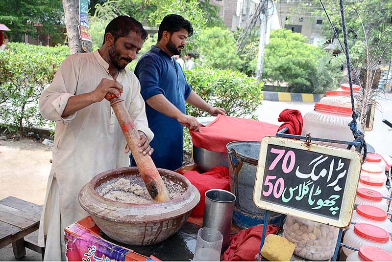 Vendor preparing traditional summer drink Sardai for customers at his roadside setup