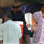 Customers are busy in drinking traditional summer drink Ghota from roadside vendor during scorching hot weather in the city