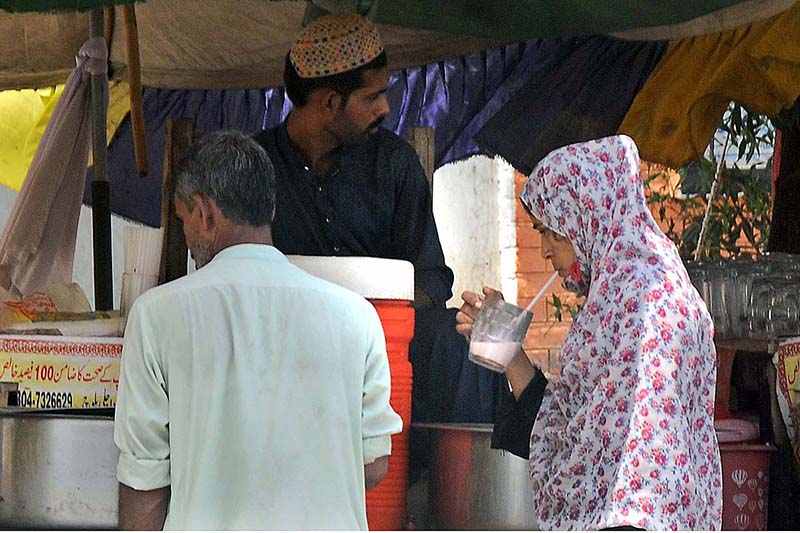Customers are busy in drinking traditional summer drink Ghota from roadside vendor during scorching hot weather in the city