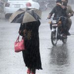 A woman on the way under cover of an umbrella to protect from rain that experience the city