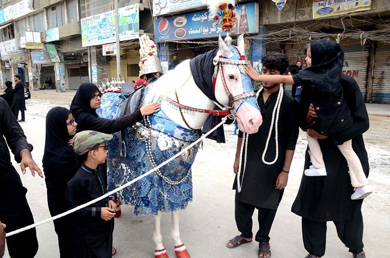 Mourners touch Tazia during the main procession of 9th Muharram-ul-Haram observing Youm-e-Ashur at M.A Jinnah Road. Muharram ul Harram, the first month of the Islamic calendar is known as the mourning month to pay homage in remembrance of the martyrdom (Shahadat) of Hazrat Imam Hussain (AS), the grandson of the Holy Prophet Mohammad (SAWW), along with his family members and companions at the battle of Karbala