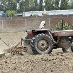 Farmers are preparing their farm field for the next crop with the help of a tractor