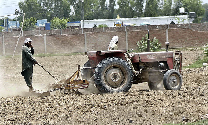 Farmers are preparing their farm field for the next crop with the help of a tractor
