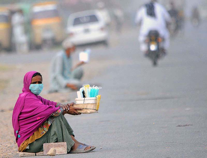 A woman vendor selling face masks while sitting at roadside