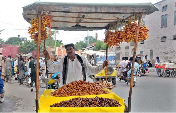 Vendor displaying fresh dates to attract the customer while shuttling on the road
