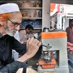 An elderly person busy in making duplicate key at Aabpara Market