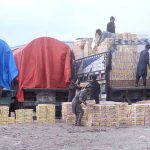 Laborers busy unloading of peach boxes from delivery truck at Pirwadhai Fruit Market.