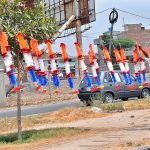 A young vendor arranging and displaying garlands to attract the customers at Airport Road