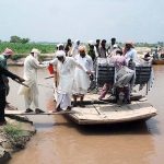 Floodwater forced people to travel in overloaded boats along with motorcycles in Patan Mangwani Mouza