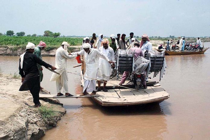 Floodwater forced people to travel in overloaded boats along with motorcycles in Patan Mangwani Mouza