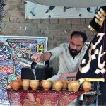 Volunteer serving Sabeel during the 06th Muharram Ul Haram procession at Shah Shams