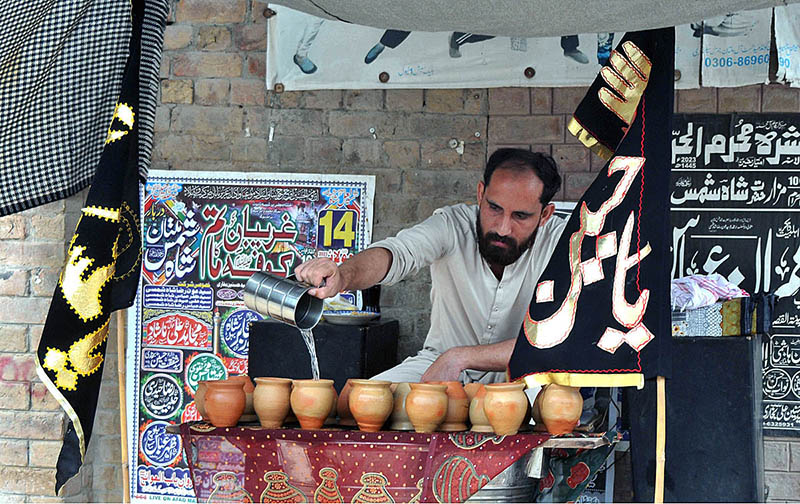 Volunteer serving Sabeel during the 06th Muharram Ul Haram procession at Shah Shams
