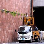 PHA staff placing bouquets of yellow flowers on the beauty wall of Kalma Chowk underpass.