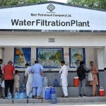 People fill their pots with clean drinking water from water filtration plant in I-8 Sector