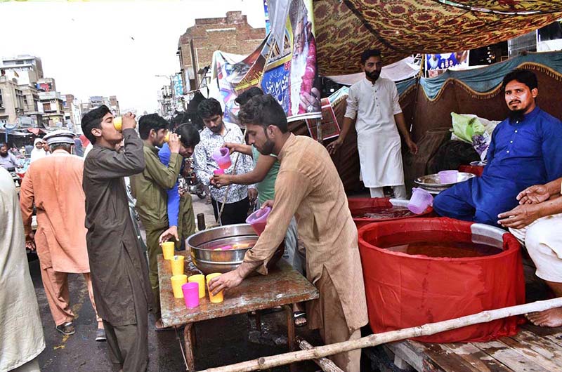 People drinking Sabeel (special drink) offer by volunteers along the roadside in connection of Ashura at Sher Kathi Bazar