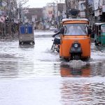 Vehicles passing through stagnant rainwater at Hazoori Bagh road