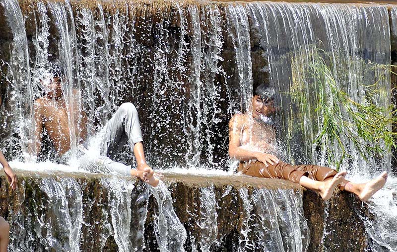 Youngsters jumping and bathing in the water channel of Rawal Dam to get some relief from hot weather in Federal Capital