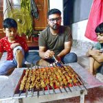 A boy preparing barbeque of meat on the occasion of 3rd day of Eid-ul-Azha at his home