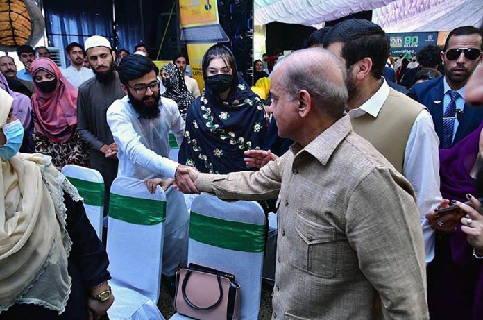 Prime Minister Muhammad Shehbaz Sharif interacts with students at the ceremony of merit-based distribution of laptops among high-achieving students under the Prime Minister's Youth Laptop Scheme 2023
