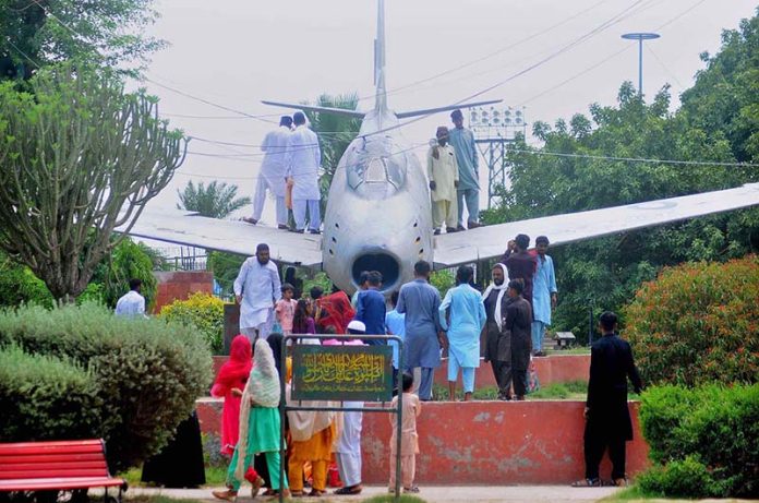 Visitors taking pictures during their visit to Qasim Bagh Park on the 3rd day of Eid ul Adha