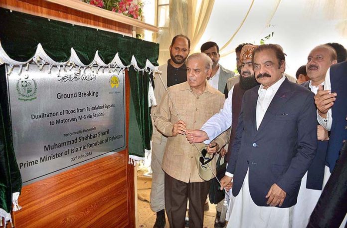 Prime Minister Muhammad Shehbaz Sharif is unveiling the plaque during groundbreaking ceremony for dualization of a road from Faisalabad Bypass to Motorway (M-3) via Satiana