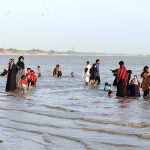 A large number of people enjoying in river water during hot weather in the city