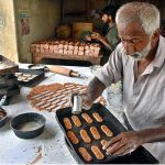 An elder worker busy in work at the a local bakery