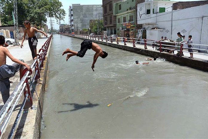 Youngsters diving in the Canal to get some relief from extreme hot weather at Gulbahar area in the city
