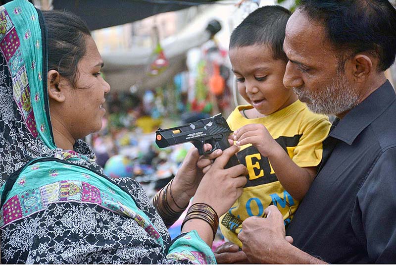 Women and children selecting and purchasing old toys at a roadside stall in Empress Market