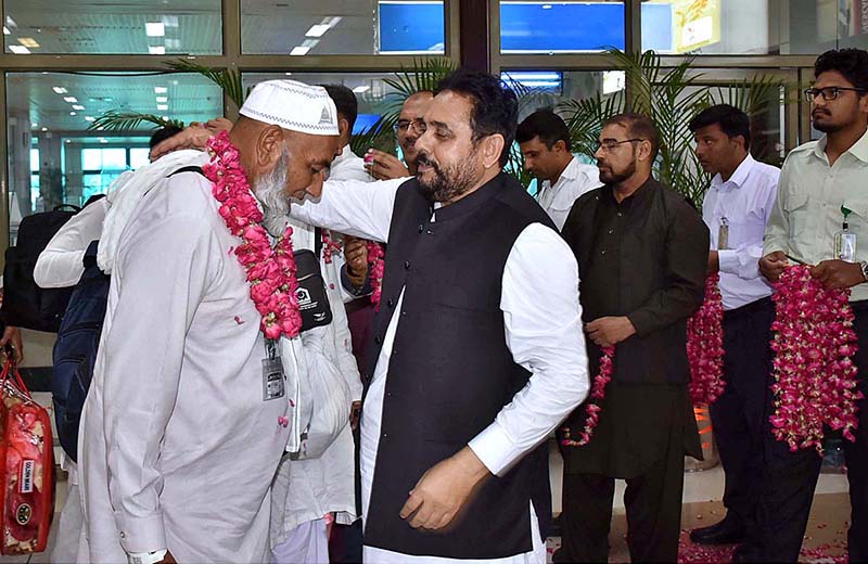 Officers welcoming the pilgrims of the first flight returning after performing the duty of Hajj