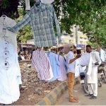 A vendor selling used shirts at his roadside setup