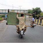 A pillion rider carrying an iron bed (Charpai) in a risky way may cause any untoward incident