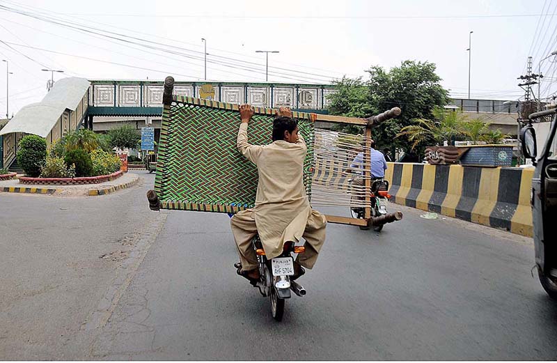 A pillion rider carrying an iron bed (Charpai) in a risky way may cause any untoward incident