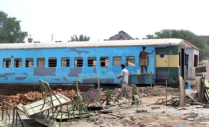 A worker is painting a train carriage with the purpose of transforming it into a functional and inviting hotel at Damdama.
