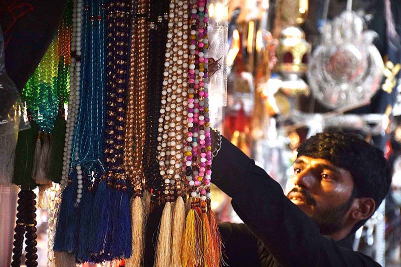 Shopkeeper displays Muharram-ul-Harram related stuff to attract the customer at Bibi Pak Daman