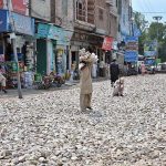 Laborers spreading stones at the road construction of Ali Chowk during development work in the city.