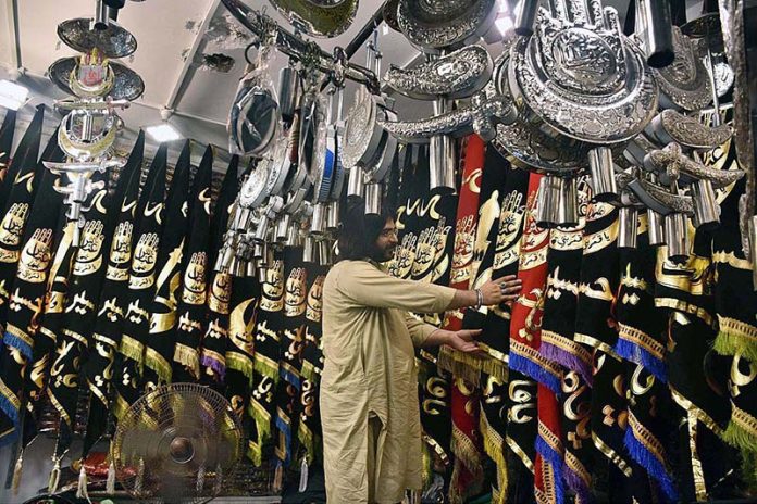 Shopkeeper displays Muharram-ul-Harram related stuff to attract the customer at Bibi Pak Daman