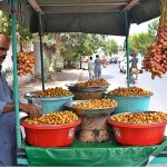 A vendor displaying and selling fresh dates at his road side setup
