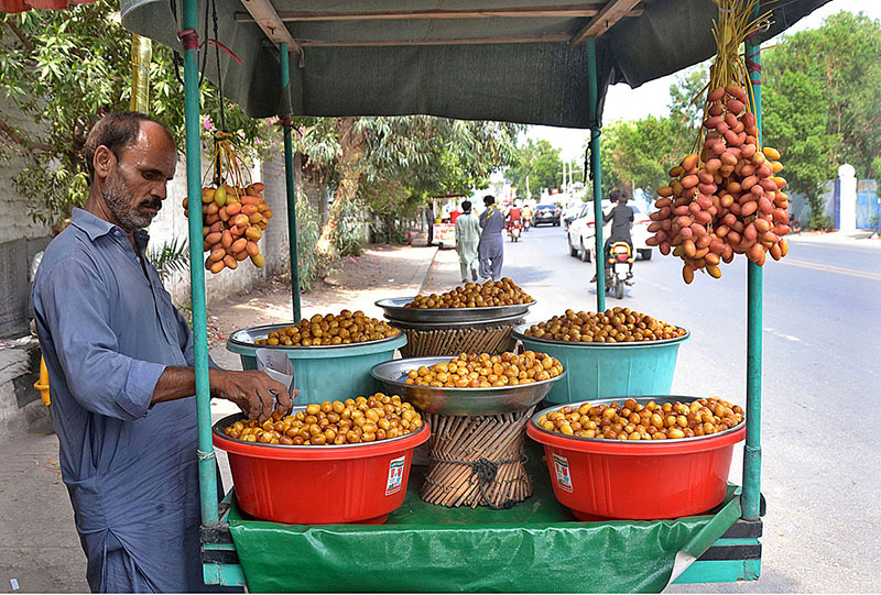 A vendor displaying and selling fresh dates at his road side setup
