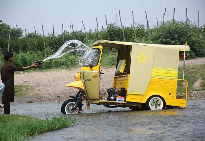 A person washing his vehicle in a stream at Dando Pull near Phandu area