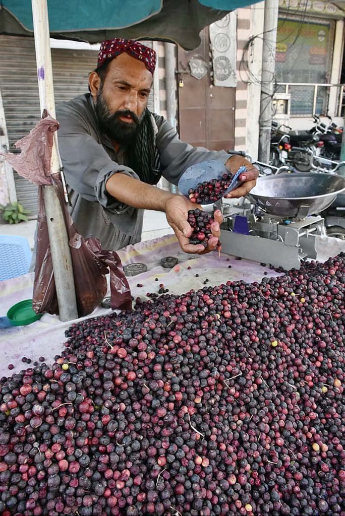 A vendor is busy displaying and arranging falsa for customers at his road side setup