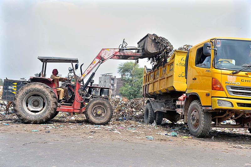 Staffer of Waste Management loading garbage on truck