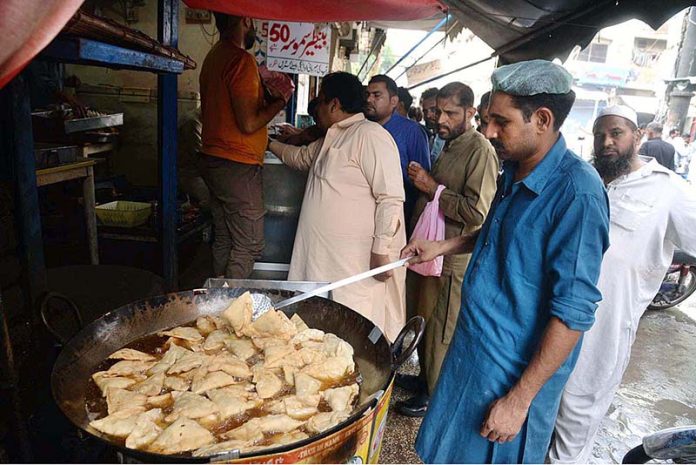 People throng at a samosa shop after heavy rains in the city