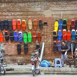 Vendor selling and displaying colorful fancy motorcycle seats to attract the customers during his roadside setup at Sarki Area