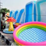 A vendor filling air in the plastic bath tubs for children displayed on footpath to attract the customers at Shaukat Ali Road in the city