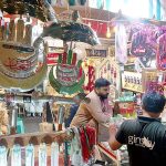 People Purchasing Muharram ul Haram related stuff displaying frm shopkeeper.