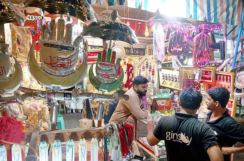 People Purchasing Muharram ul Haram related stuff displaying frm shopkeeper.