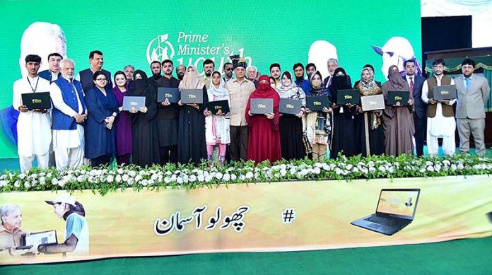 Prime Minister Muhammad Shehbaz Sharif in a group photo with the high-achievers who received laptops on merit basis under the Prime Minister's Youth Laptop Scheme 2023
