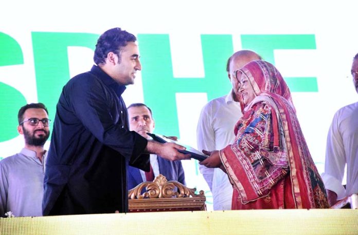 Chairman PPP and Foreign Minister Bilawal Bhutto Zardari handing over the land titles to flood affectees people in a ceremony at Dhamra Village